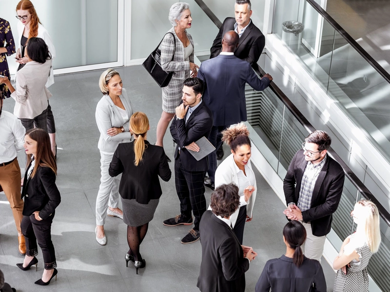 A large group of businesspeople talking in the hallway.